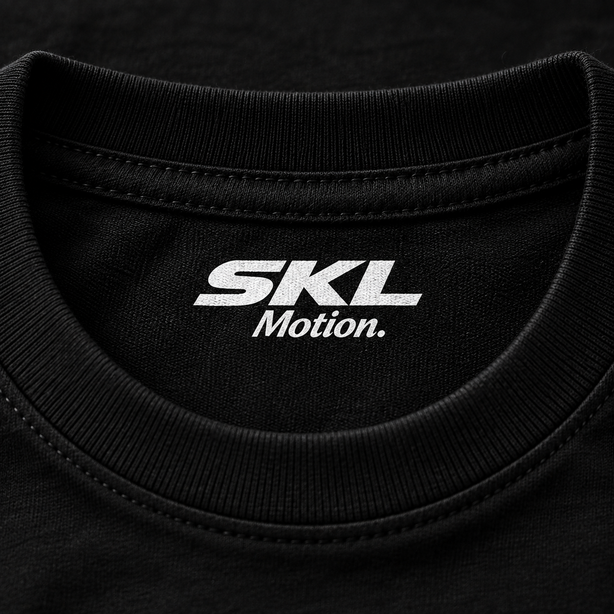 Détail du col intérieur du t-shirt noir SKL Motion avec marquage blanc sans étiquette cousue