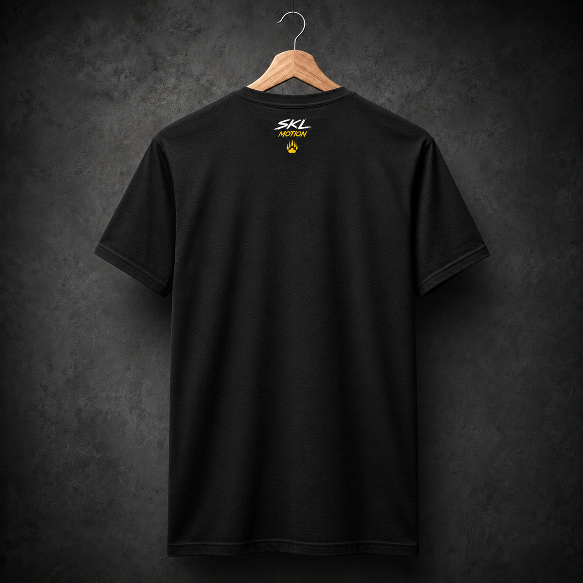 T-shirt snowboard SKL Motion noir sur cintre, vue de dos avec logo blanc jaune et patte